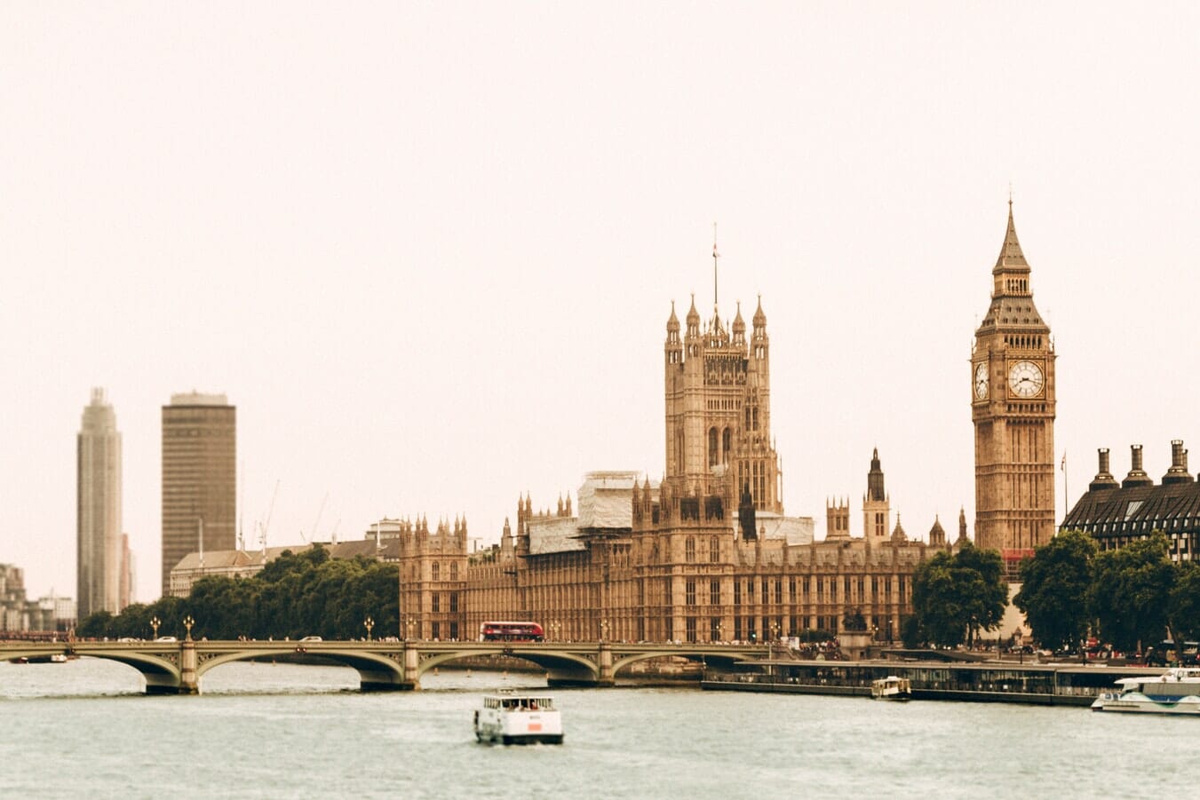 A boat is traveling down a river in London to deliver tax documents.