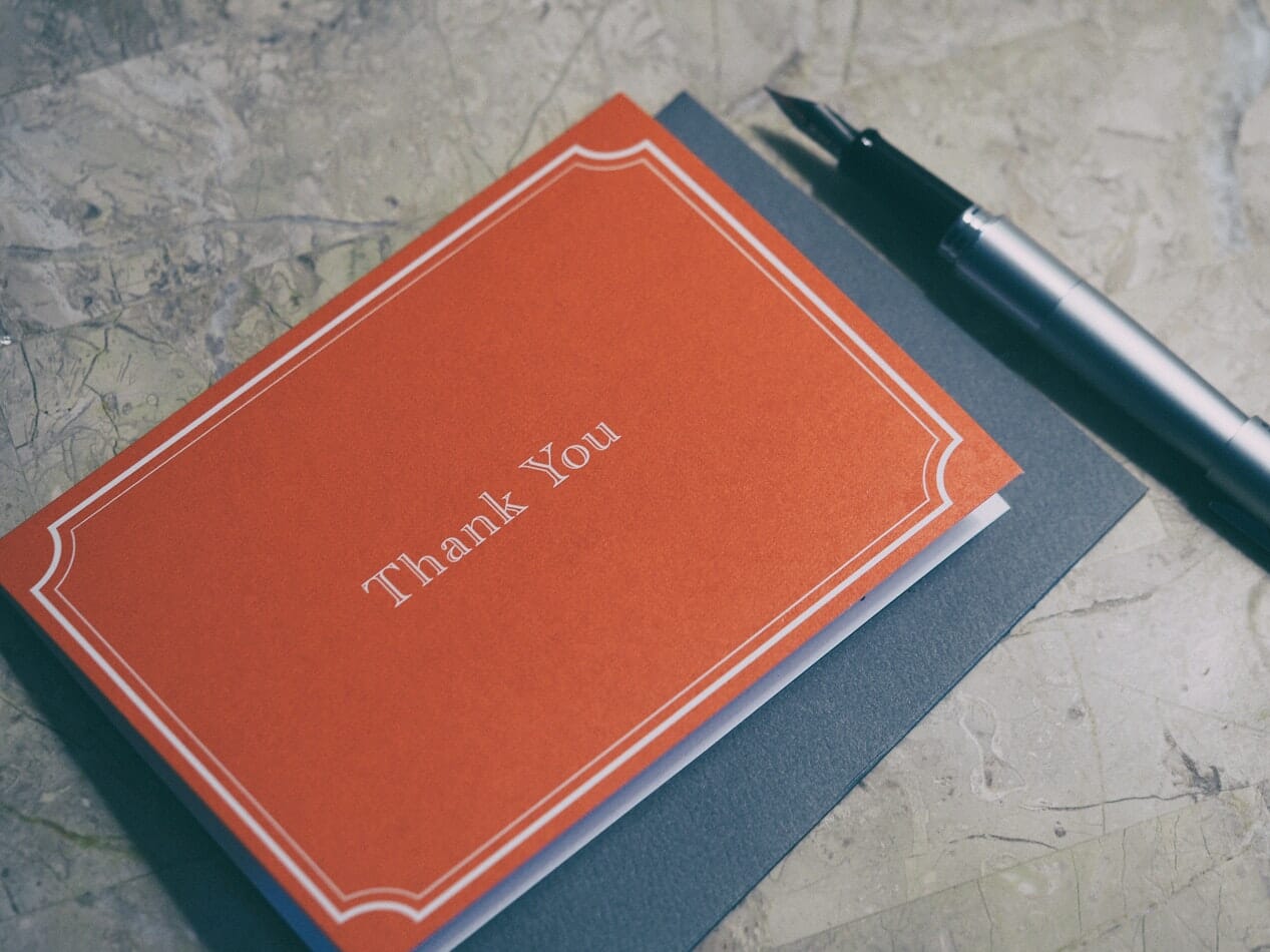 A tax refund thank you card with a pen on top.