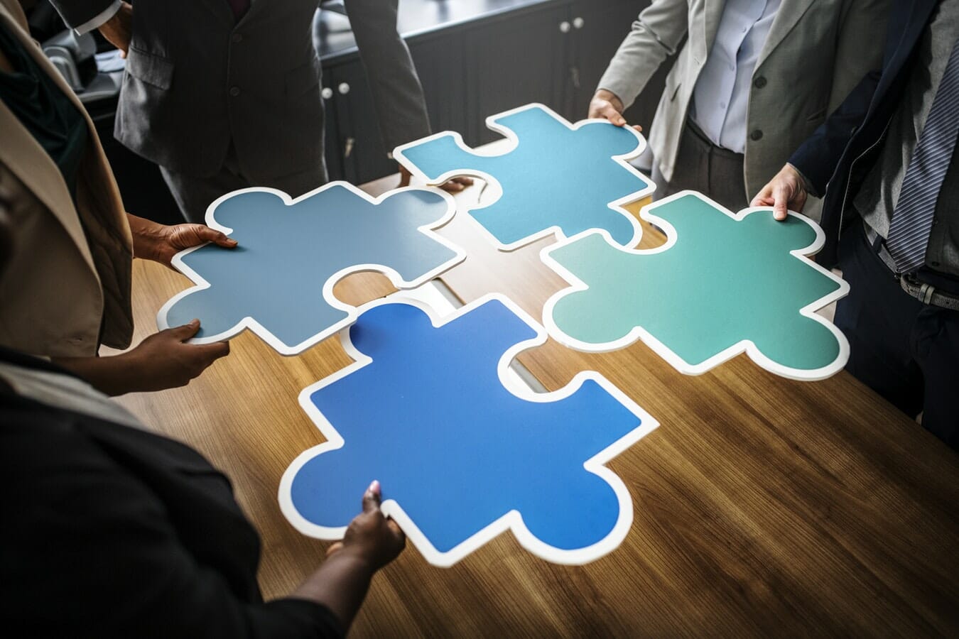 A group of business people holding jigsaw puzzle pieces, discussing IR35.
