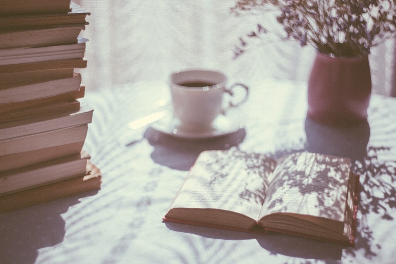 A stack of books and a cup of coffee on a table, offering an insider's perspective.