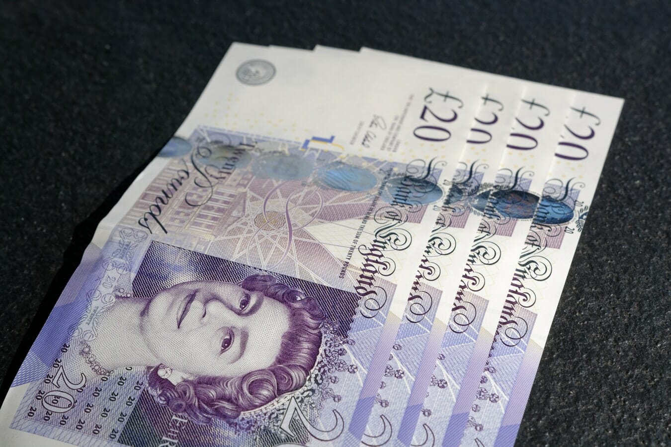 British banknotes on a black surface.