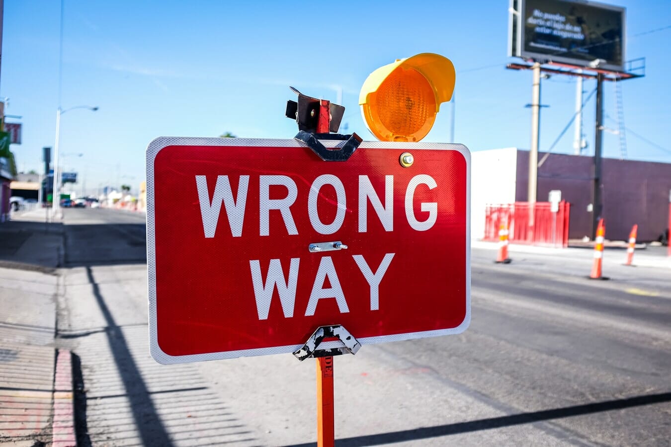 A red and white sign that says wrong way.