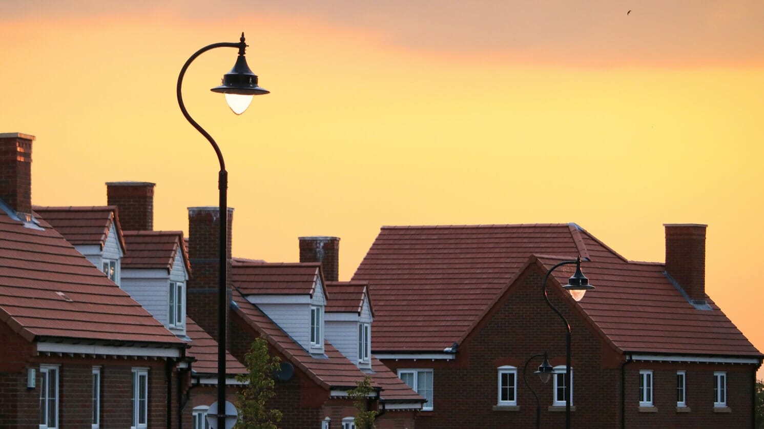 A street light in front of a row of houses.