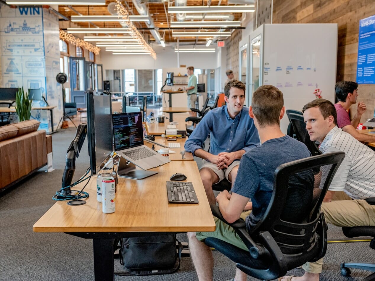 A group of people sitting at desks in an office.