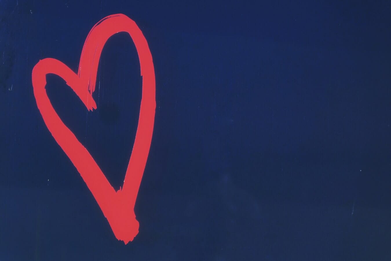 A red heart painted on a blue wall.