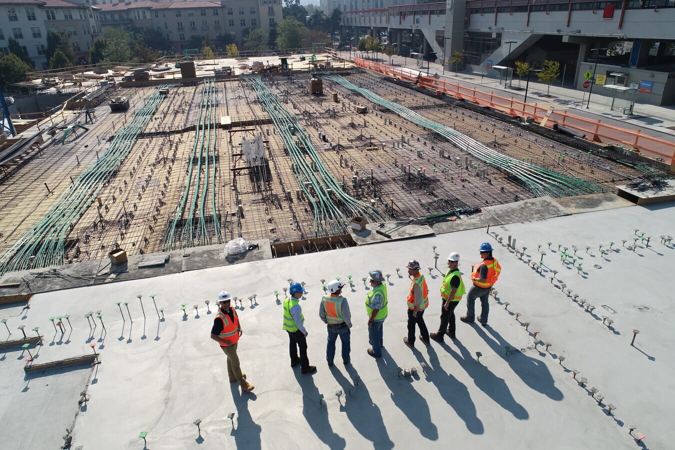 A group of construction workers standing on a construction site.