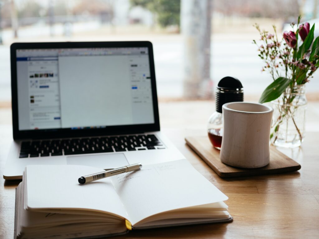 Laptop, diary and mug on workstation