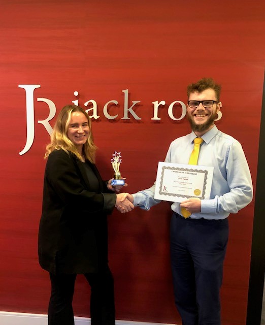 Jacob being handed Employee of the Month trophy