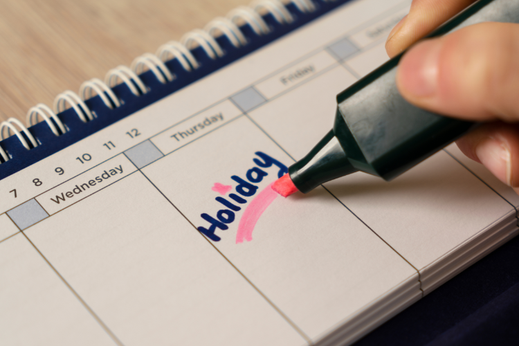 A person writing on a calendar with a marker.